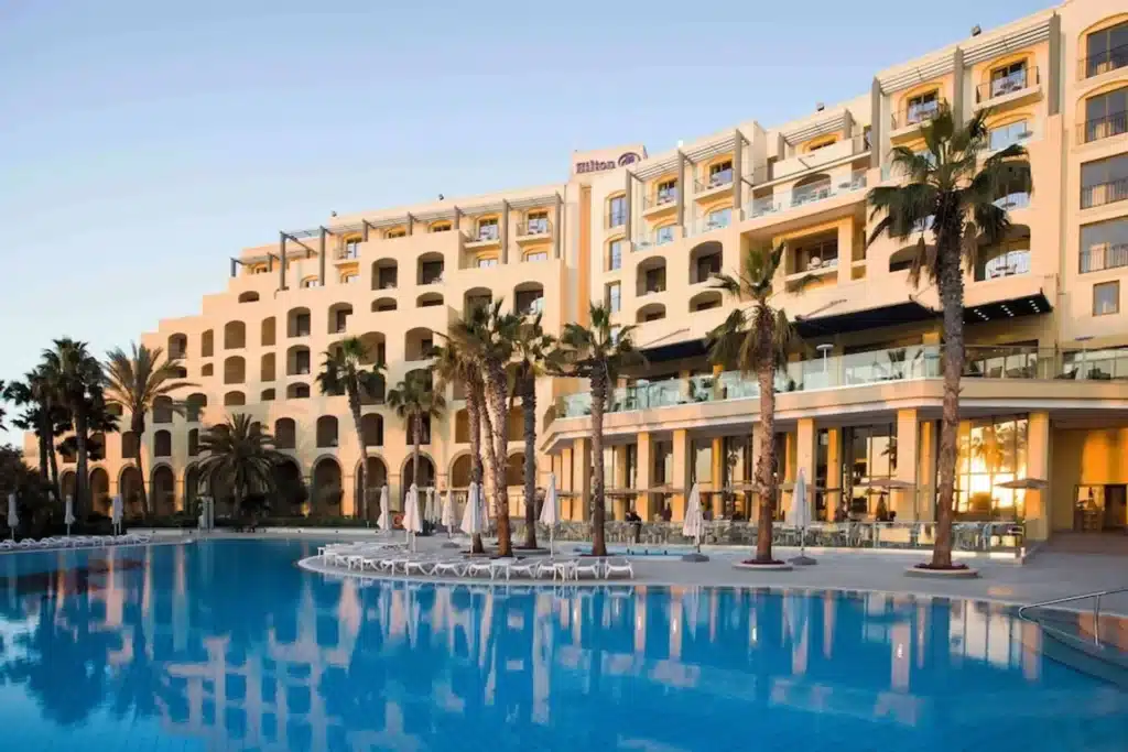 Hilton Malta hotel exterior view overlooking the Mediterranean Sea in St. Julian's, Malta - luxury 5-star beachfront resort with outdoor pool
